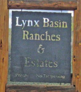 Metal entry sign saying Lynx Basin Ranches and Estates